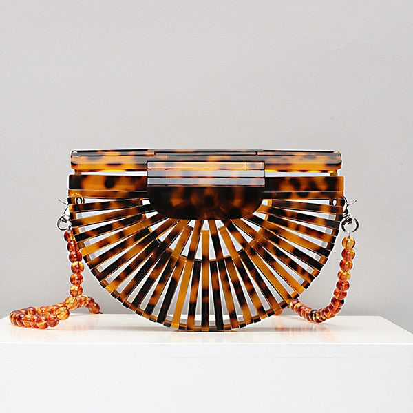 This Half Moon Bag is a half circle, acrylic basket design. This clutch bag is beautifully crafted, easy to clean and looks gorgeous. Removeable beaded or black cross over straps.
