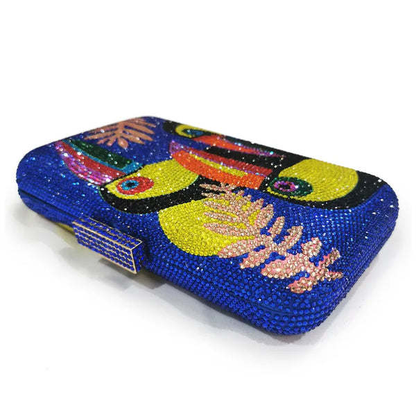 The Crystal Bird Clutch Purse is an mmbellished toucan parot clutch purse, covered with tiny colored crystal rhinestones. Finished with detail clasp closure.