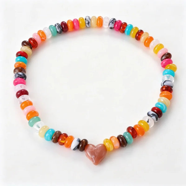 A multicolor dog beaded stretch bracelet with a heart-shaped charm, displayed on a clean white background.