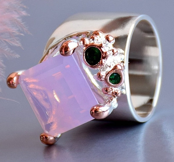 Dusk pink zircon ring made of copper, rose gold + light green plated. Abstract, modern design. Has a silver shine finish. Rectangle cut in a prong setting. 