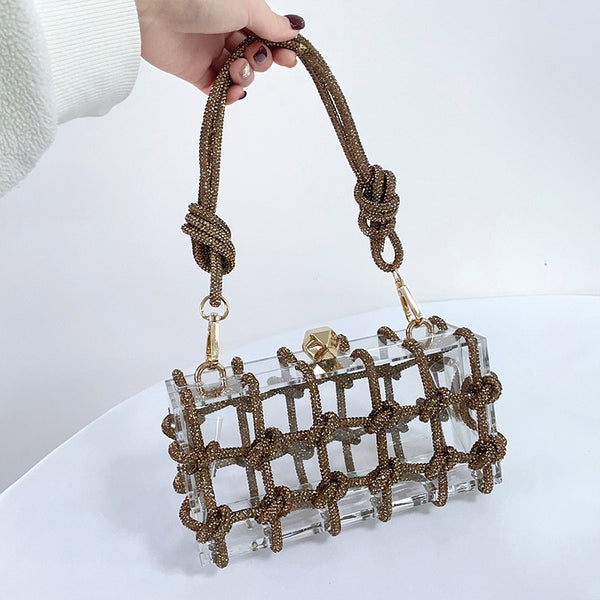 The Herra Rope Box Clutch is a clear acrylic box clutch, wrapped in knotted glitter rope. Finished with crystalline shaped clasp. Bag suitable for any special occassion.
