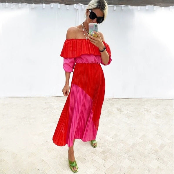 Sash waisted, lantern sleeve brightly hued hot pink and red full circle, pleated crepe skirt dress. Neck wide for off shoulder.