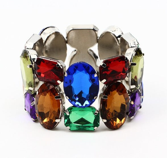 Wild Rhinestone is a cuff dress, stretch resin beaded angular 50s retro bracelet, which stretches to fit any hand. Elasticated for easy wear. Each shiny bead is irregular, brightly coloured and silver color plated on the back. In an array of multi colored gems. One size.