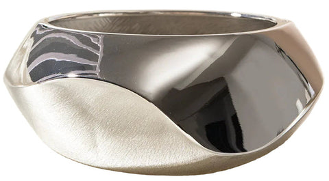 This large bangle features a striking geometric design in silver and gold tones, offering a modern and versatile accessory for any outfit. 