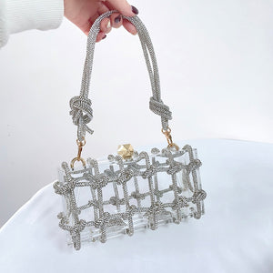 The Herra Rope Box Clutch is a clear acrylic box clutch, wrapped in knotted glitter rope. Finished with crystalline shaped clasp. Bag suitable for any special occassion.