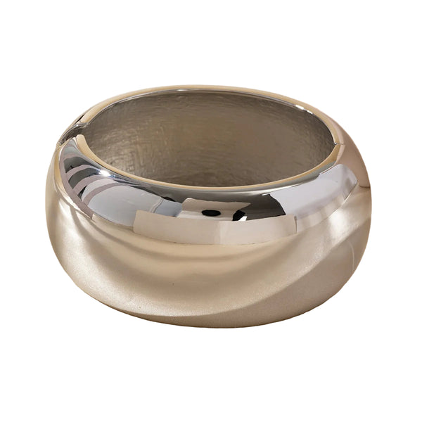 This large bangle bracelet features a striking geometric design in silver and gold tones, offering a modern and versatile accessory for any outfit. 