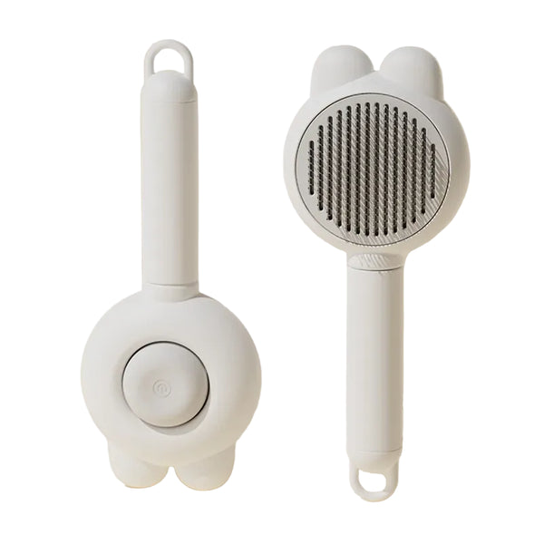 White handheld grooming tool with a brush head on a beige background