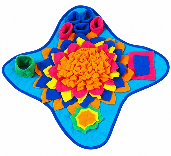 A colorful felt dog and cat sensory play mat with a blue star-shaped base, featuring a central orange flower, pink and yellow petals, and various colored sensory pockets including a green cup, blue loops, and a pink square.