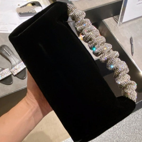 This sophisticated Rhinestone & Velvet Clutch is sure to be a showstopper. The clutch has a sparkling rhinestone-encrusted handle and a plush velvet lining for added luxury. 