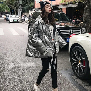 The Silver hooded cropped bomber jacket is loose, large fit. 80% duck down. Zip on sleeve. In Gold, Silver and Black. Sits around the hip level, choose a larger size for a baggy look.