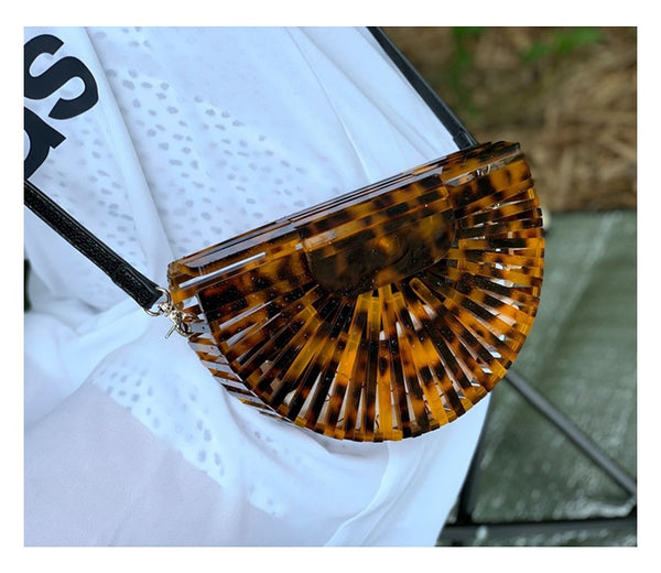 This Half Moon Bag is a half circle, acrylic basket design. This clutch bag is beautifully crafted, easy to clean and looks gorgeous. Removeable beaded or black cross over straps.