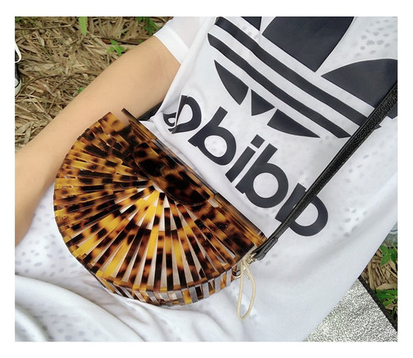 This Half Moon Bag is a half circle, acrylic basket design. This clutch bag is beautifully crafted, easy to clean and looks gorgeous. Removeable beaded or black cross over straps.