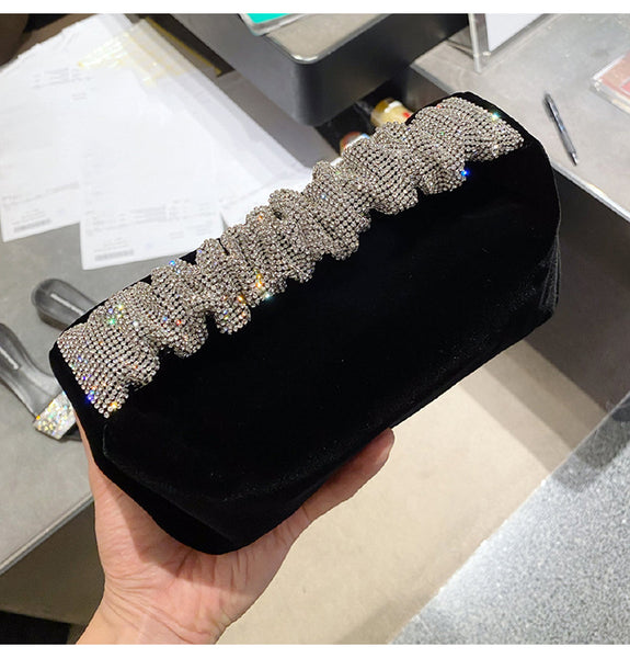 This sophisticated Rhinestone & Velvet Clutch is sure to be a showstopper. The clutch has a sparkling rhinestone-encrusted handle and a plush velvet lining for added luxury. 