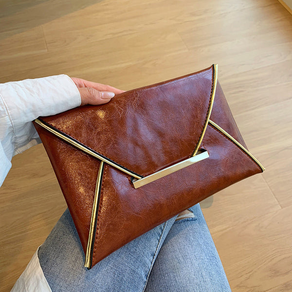The Snake Pattern Envelope Clutch Sis a flat, lined envelope clutch bag with colored alligator snake pattern. Magnetic metal tab closure. In 100 Percent PU eco leather.