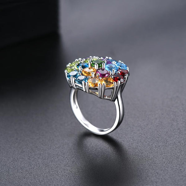 The Dream Gem Ring is a delightful multi colored gemstone silver cluster ring. It includes a halo of blue topaz, green peridot, garnet, yellow citrine and amethyst. 
